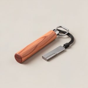 Birch Fire Starter — ferro rod fire starter with a wooden handle, steel striker and paracord lanyard on a light grey backdrop