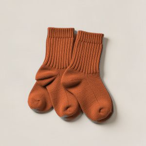 Cedar Camp Sock in Rust — pair of thick ribbed camp socks on a light grey backdrop
