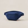 Cedar Hip Pack in Navy — compact hip pack with a zipped front pocket and a buckled waist strap on a light grey backdrop
