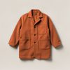 Driftwood Chore Coat in Rust — boxy button-front chore coat with two patch pockets on a light grey backdrop