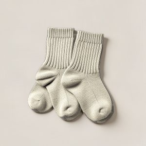 Ember Camp Sock in Cream — pair of thick ribbed camp socks on a light grey backdrop