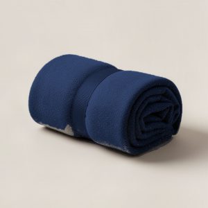 Ember Camp Throw in Navy — soft camp throw blanket, rolled with a strap on a light grey backdrop