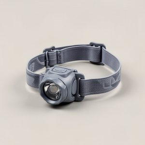 Ember Headlamp in grey — compact headlamp with a lens housing and an elastic headband on a light grey backdrop