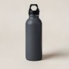 Ember Steel Bottle in Charcoal — tall insulated steel water bottle with a screw-on cap and carry loop on a light grey backdrop