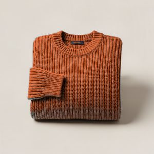 Ember Watch Sweater in Rust — chunky ribbed-knit crew-neck sweater, folded on a light grey backdrop