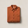 Cedar Flannel Shirt in Rust — button-up flannel shirt, folded on a light grey backdrop