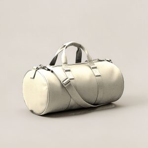 Foxfire Duffel in Cream — cylindrical duffel bag with carry handles and a shoulder strap on a light grey backdrop