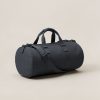 Granite Duffel in Charcoal — cylindrical duffel bag with carry handles and a shoulder strap on a light grey backdrop