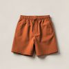 Granite Trail Short in Rust — lightweight trail shorts with an elastic drawcord waist, folded on a light grey backdrop