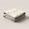 Harbor Quilted Throw in Cream — quilted throw with diamond stitching, folded on a light grey backdrop