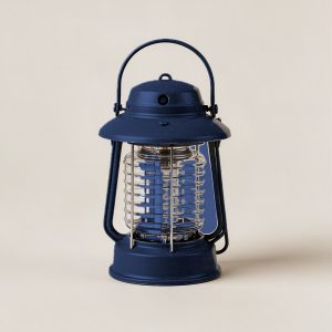Juniper Lantern in Navy — camp lantern with a domed top, carry handle and ribbed diffuser on a light grey backdrop