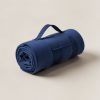 Juniper Stadium Blanket in Navy — compact stadium blanket, rolled with a carry strap on a light grey backdrop