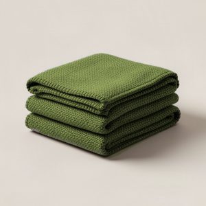 Juniper Wool Blanket in Moss — thick woven wool blanket with stitched edges, folded on a light grey backdrop