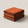 Juniper Wool Blanket in Rust — thick woven wool blanket with stitched edges, folded on a light grey backdrop