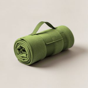 Lakeside Stadium Blanket in Moss — compact stadium blanket, rolled with a carry strap on a light grey backdrop