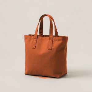 Lakeside Tote in Rust — canvas tote bag with two flat handles on a light grey backdrop