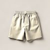 Lakeside Trail Short in Cream — lightweight trail shorts with an elastic drawcord waist, folded on a light grey backdrop