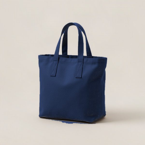 Ridgeline Tote in Navy — canvas tote bag with two flat handles on a light grey backdrop