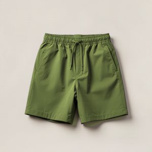 Tamarack Trail Short in Moss — lightweight trail shorts with an elastic drawcord waist, folded on a light grey backdrop