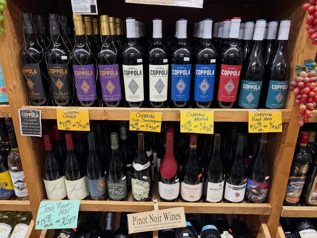 Shelves of Coppola wines and pinot noir with handwritten price signs