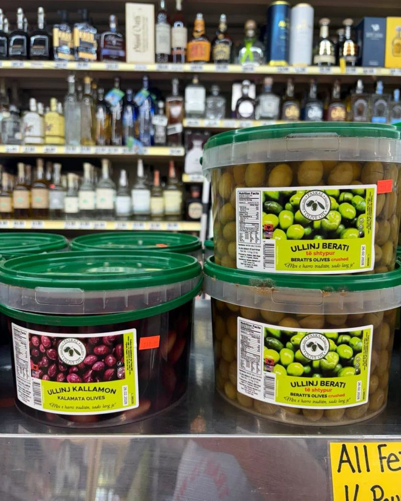 Tubs of olives in front of the liquor wall