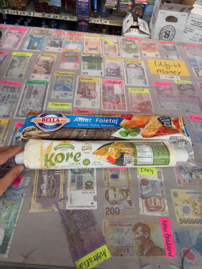 Phyllo dough on the counter over banknotes labeled Italy, New Zealand and Australia